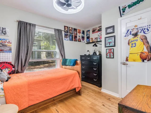 a bedroom with a bed and wooden floor
