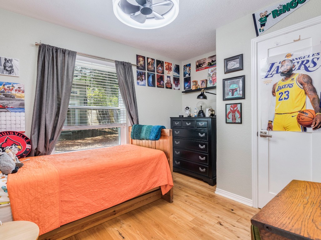 1008 Riviera Drive Cedar Park, TX 78613 - Photo 16 of 32 a bedroom with a bed and wooden floor