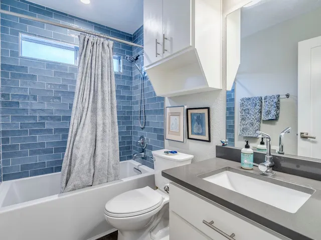 a bathroom with a granite countertop sink toilet and shower