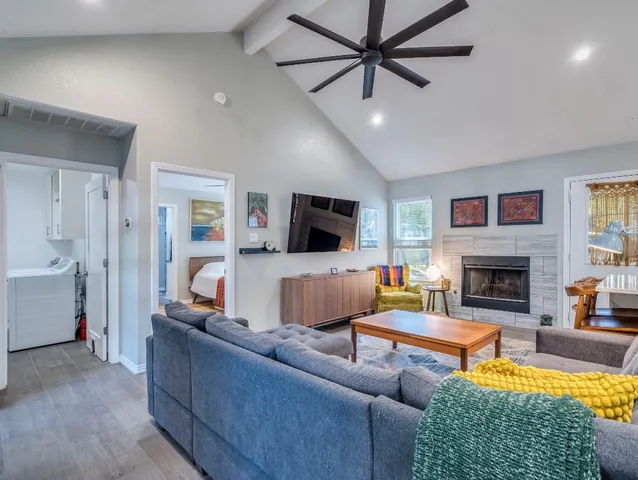 a living room with furniture a flat screen tv and a fireplace