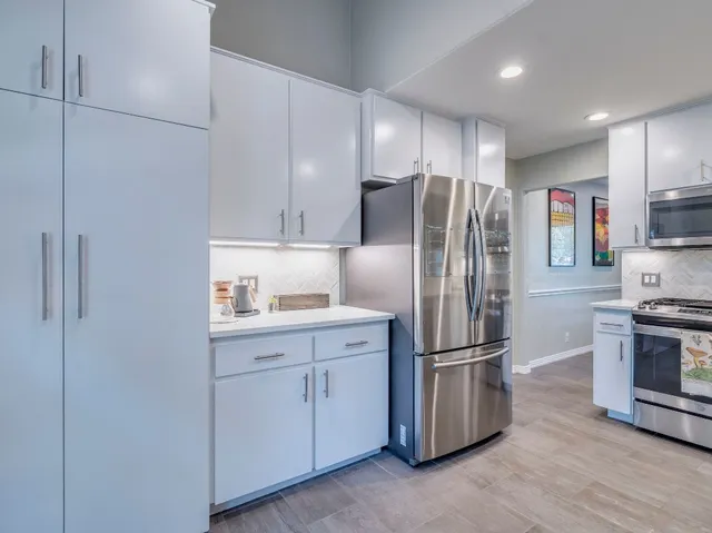 a kitchen with stainless steel appliances granite countertop a refrigerator sink and stove