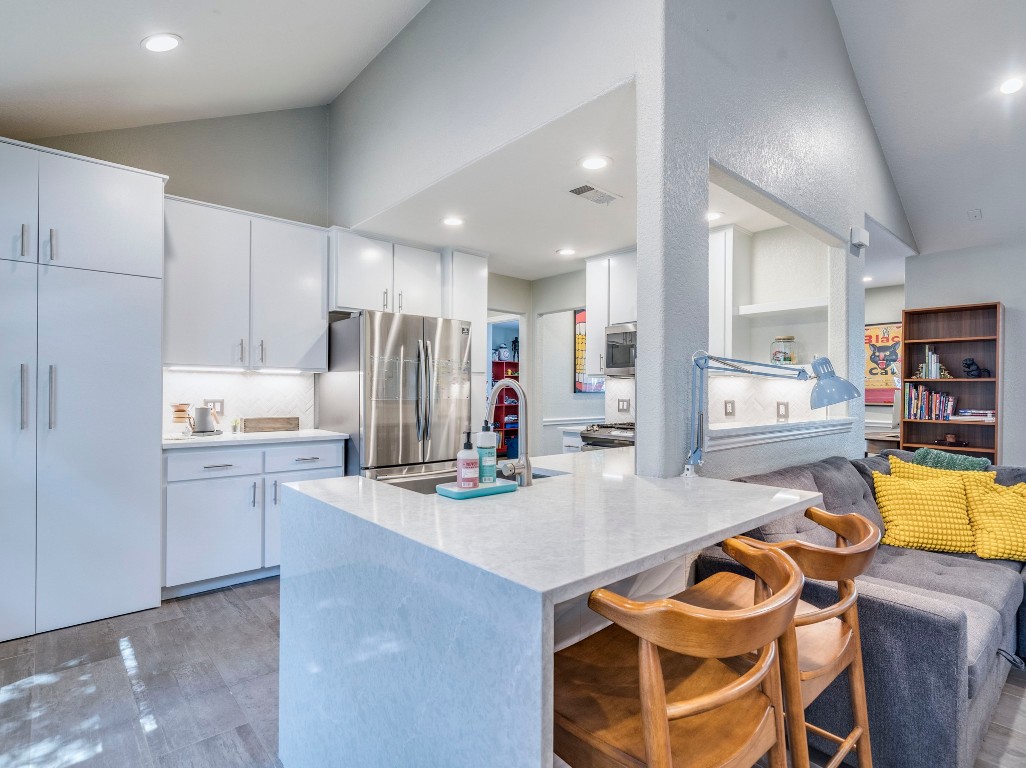 1008 Riviera Drive Cedar Park, TX 78613 - Photo 10 of 32 a kitchen with stainless steel appliances granite countertop a sink refrigerator and cabinets