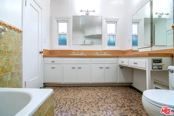 a bathroom with a sink a toilet and mirror