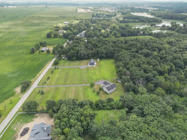 an aerial view of residential houses with outdoor space and trees