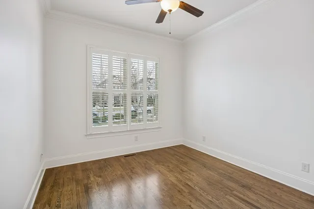 an empty room with a window and a ceiling fan