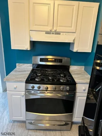 a stove top oven sitting inside of a kitchen