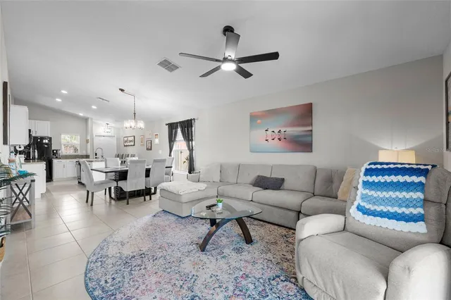 a living room with furniture and a view of kitchen