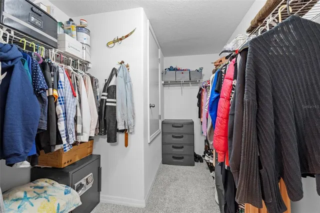 a view of walk in closet with clothes and shoes