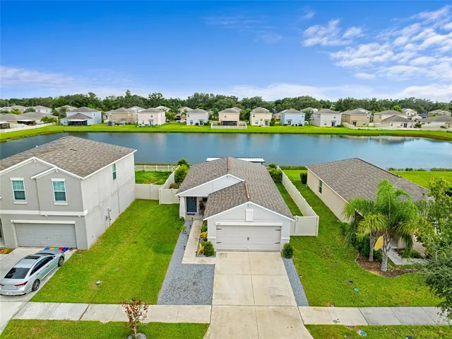 an aerial view of a house with a garden and lake view