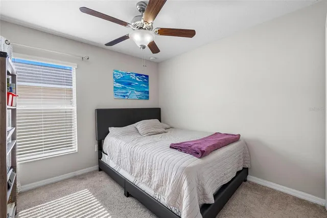 a bedroom with a bed and a ceiling fan