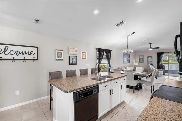 a open kitchen with stainless steel appliances kitchen island a white cabinets and couches chair