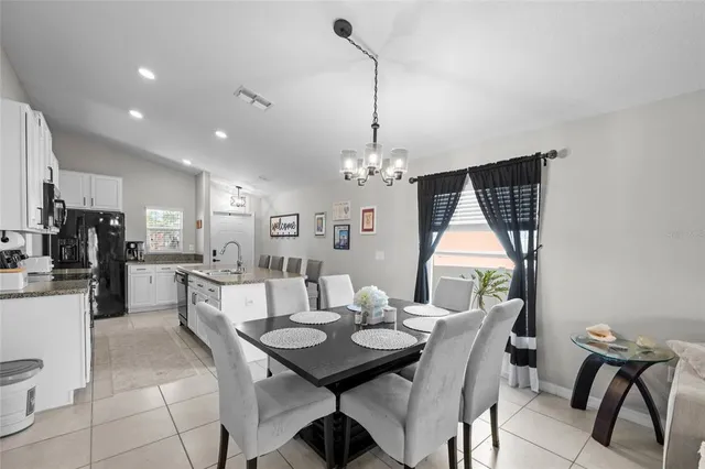 a view of a dining room with furniture and a chandelier