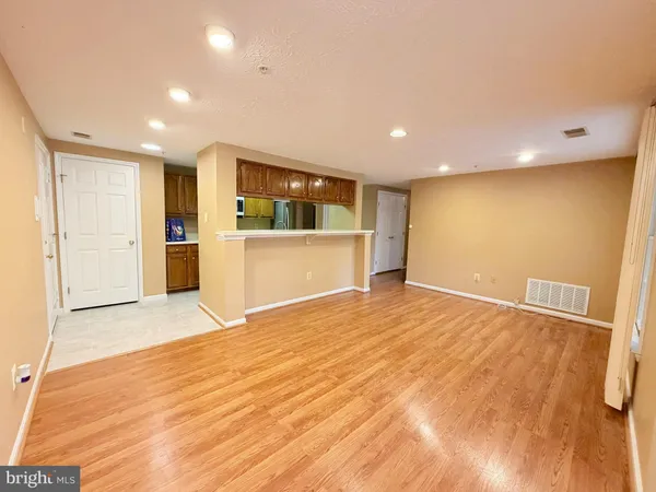 a view of empty room with wooden floor