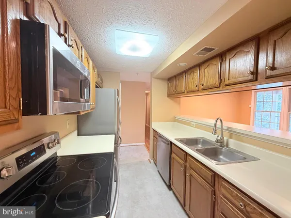 a kitchen with stainless steel appliances granite countertop a sink stove and cabinets