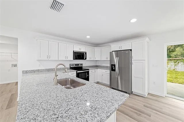 a kitchen with stainless steel appliances granite countertop a sink stove and refrigerator