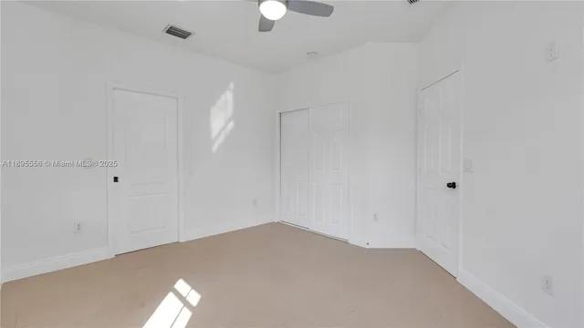 a view of white house with a yard and potted plants
