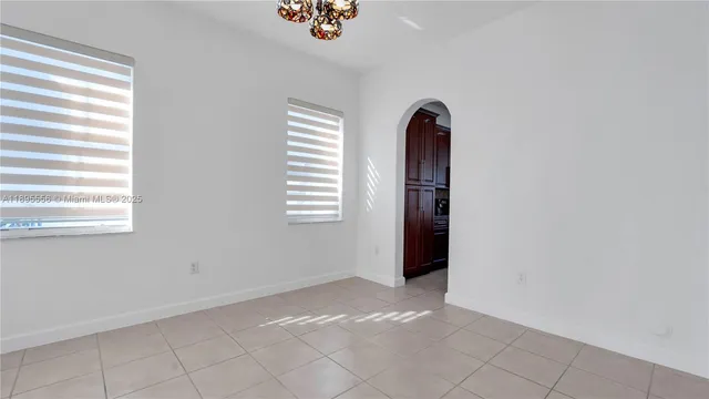 a view of a hallway with entryway windows and a kitchen view