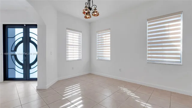 a view of a livingroom with a chandelier fan and windows