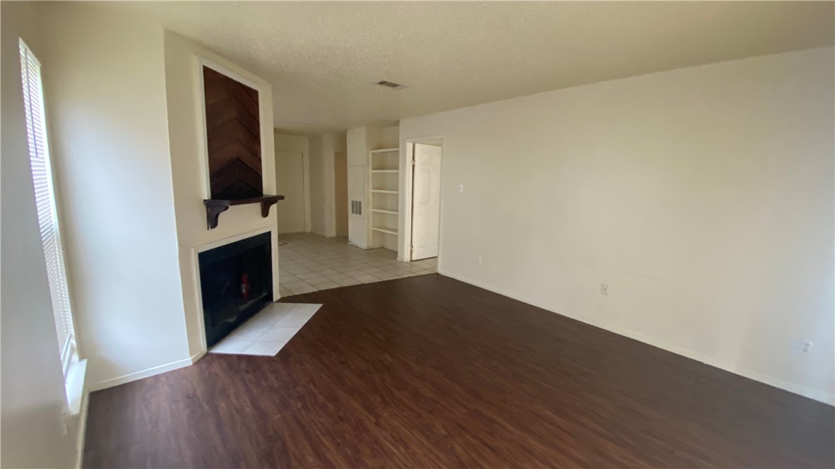 1908 West Loop, Unit A Austin, TX 78758 - Photo 3 of 13 an empty room with wooden floor and windows