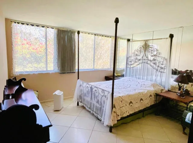 a bathroom with a sink and large mirror with toilet