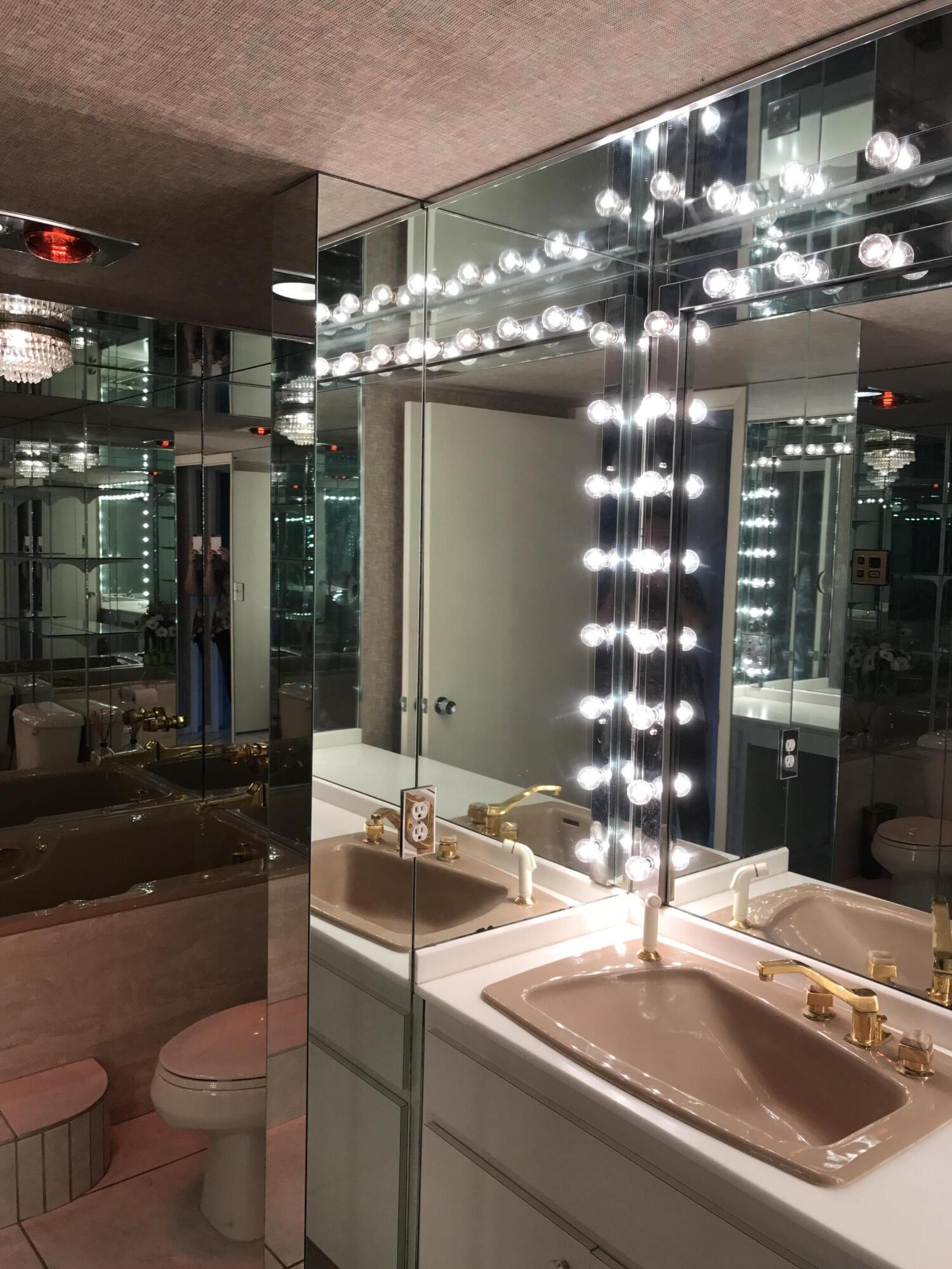 2520 Presidential Way, Unit 205 West Palm Beach, FL 33401 - Photo 12 of 22 a bathroom with a sink and large mirror with toilet