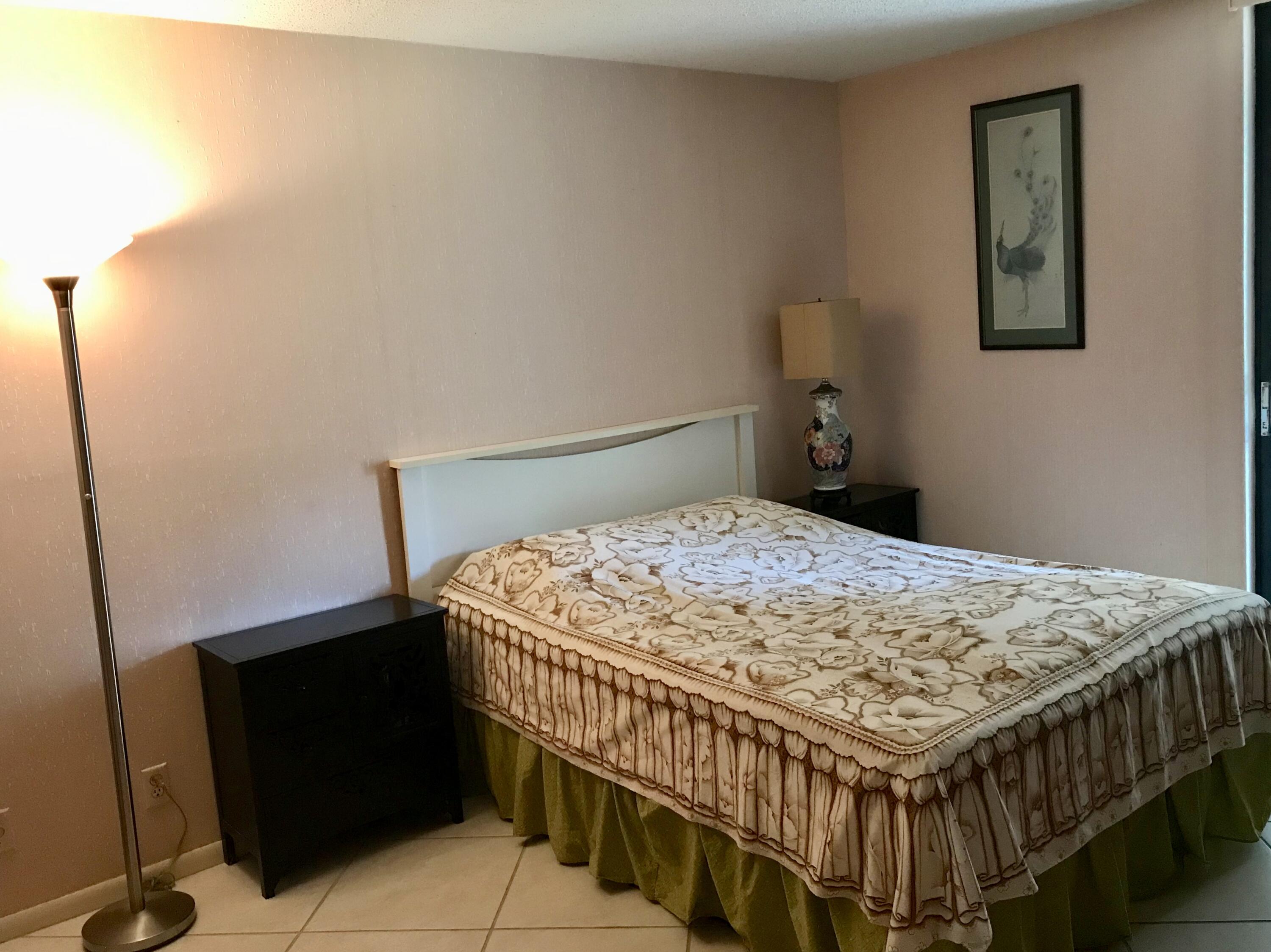 2520 Presidential Way, Unit 205 West Palm Beach, FL 33401 - Photo 14 of 22 a bed sitting in a bedroom next to a window