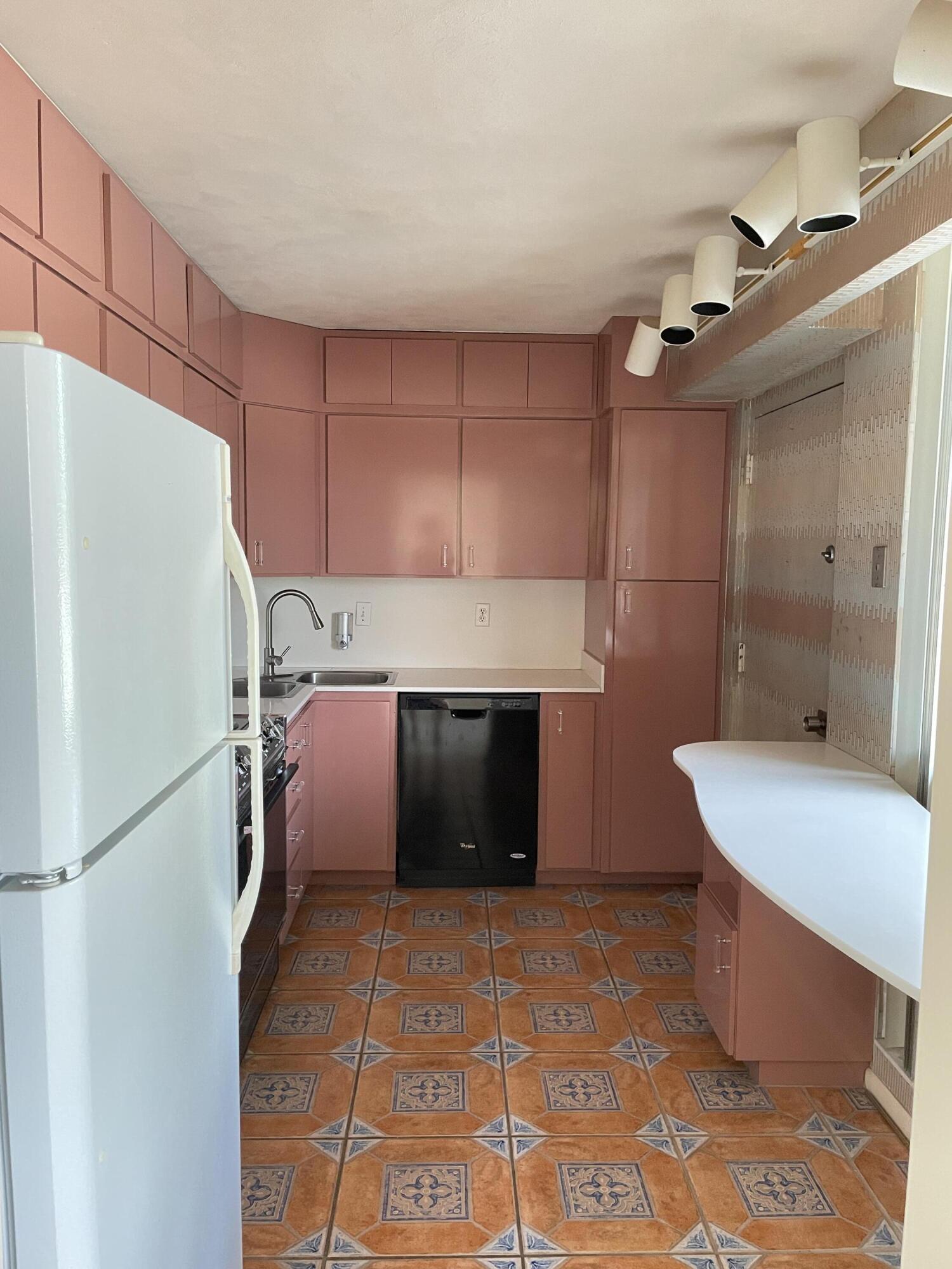 2520 Presidential Way, Unit 205 West Palm Beach, FL 33401 - Photo 17 of 22 a kitchen with a refrigerator and a sink