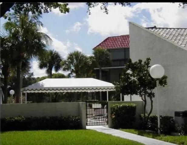 a view of a house with pool and chairs