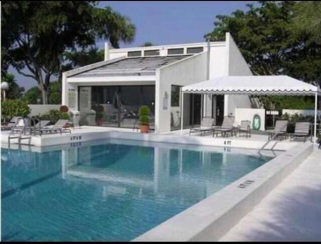 2520 Presidential Way, Unit 205 West Palm Beach, FL 33401 - Photo 20 of 22 a view of a house with pool and chairs