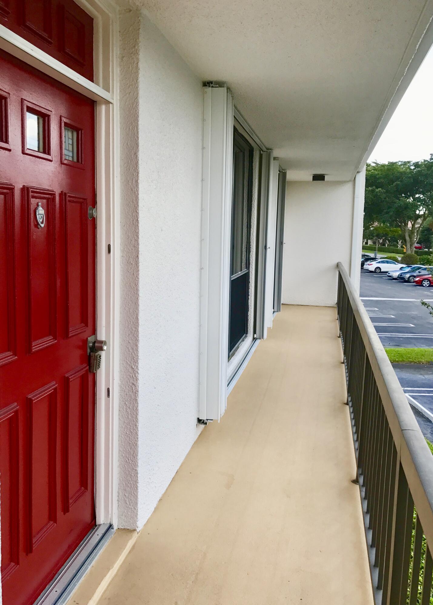 2520 Presidential Way, Unit 205 West Palm Beach, FL 33401 - Photo 4 of 22 a view of hallway with a large window and wooden floor