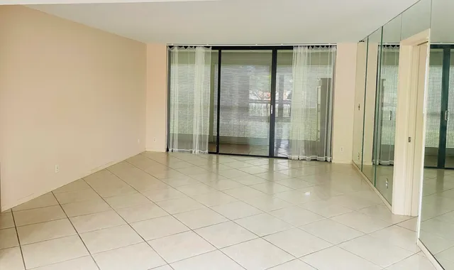 a living room with a large window and furniture
