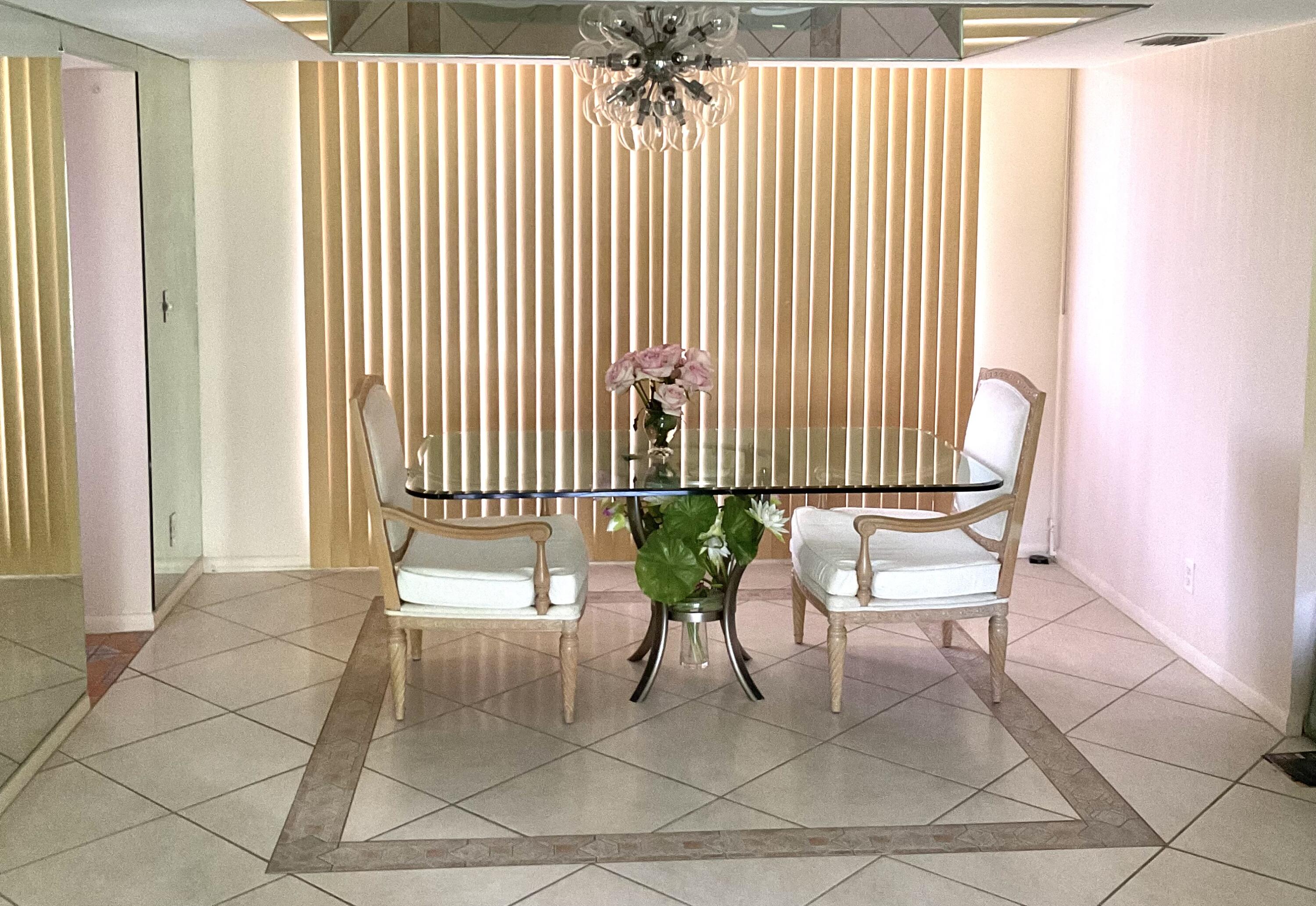 2520 Presidential Way, Unit 205 West Palm Beach, FL 33401 - Photo 9 of 22 a porch with a chair and a rug