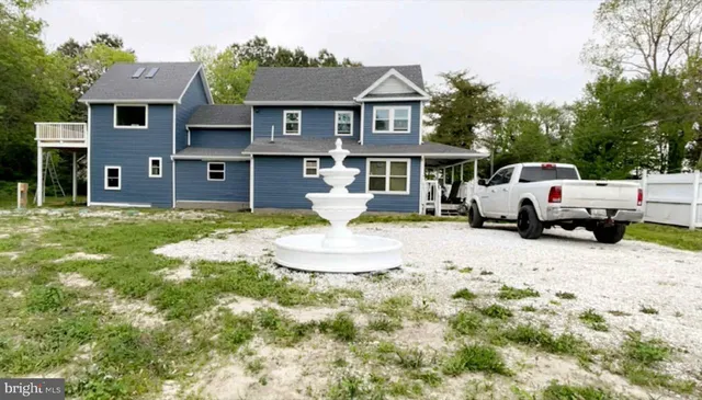 a view of a house with a big yard and large tree