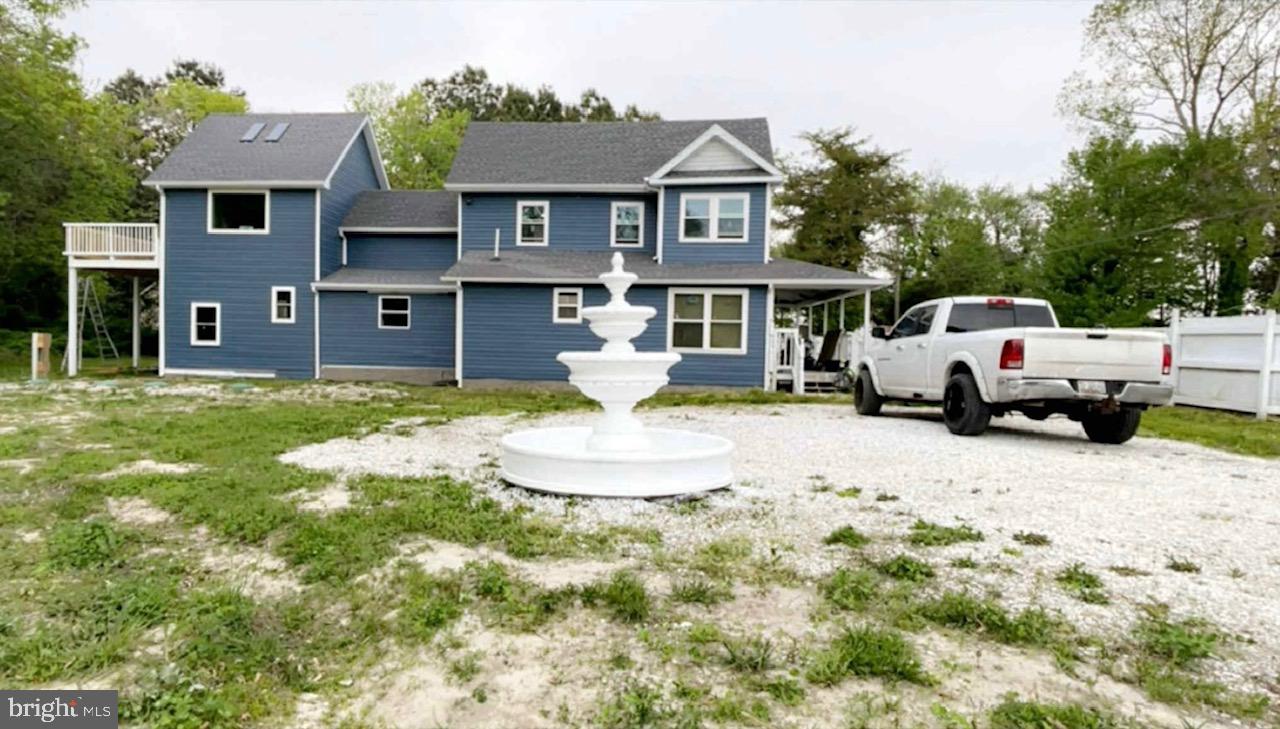 a view of a house with a big yard and large tree