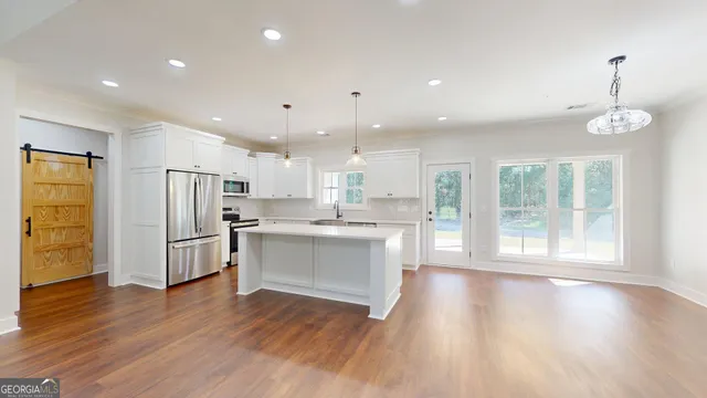 a view of kitchen with stainless steel appliances refrigerator oven microwave and cabinets