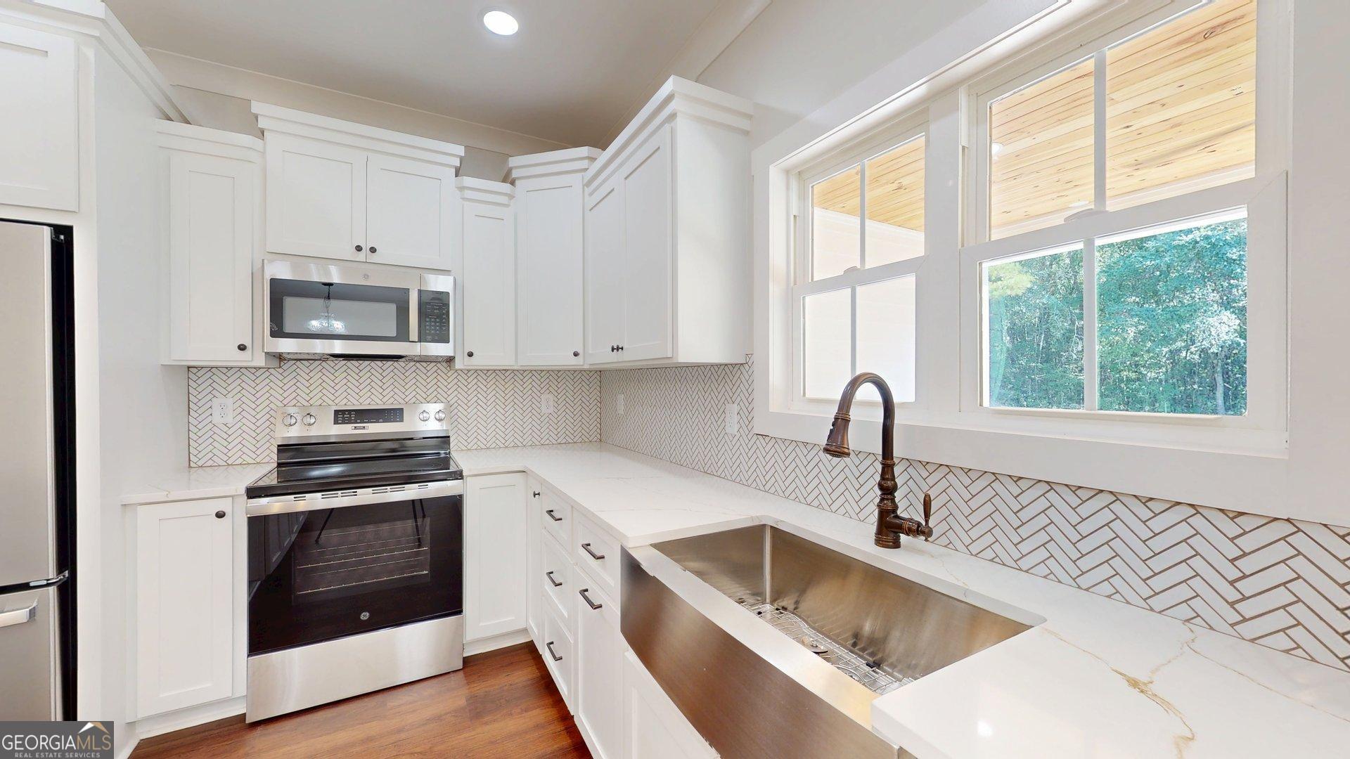 53 Jericho Lane Brooklet, GA 30415 - Photo 18 of 54 a kitchen with stainless steel appliances granite countertop white cabinets a stove a sink and a microwave