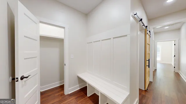 a view of a hallway with wooden floor and closet area