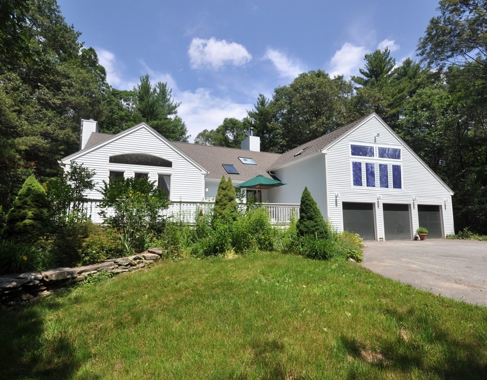 a front view of a house with a yard and potted plants