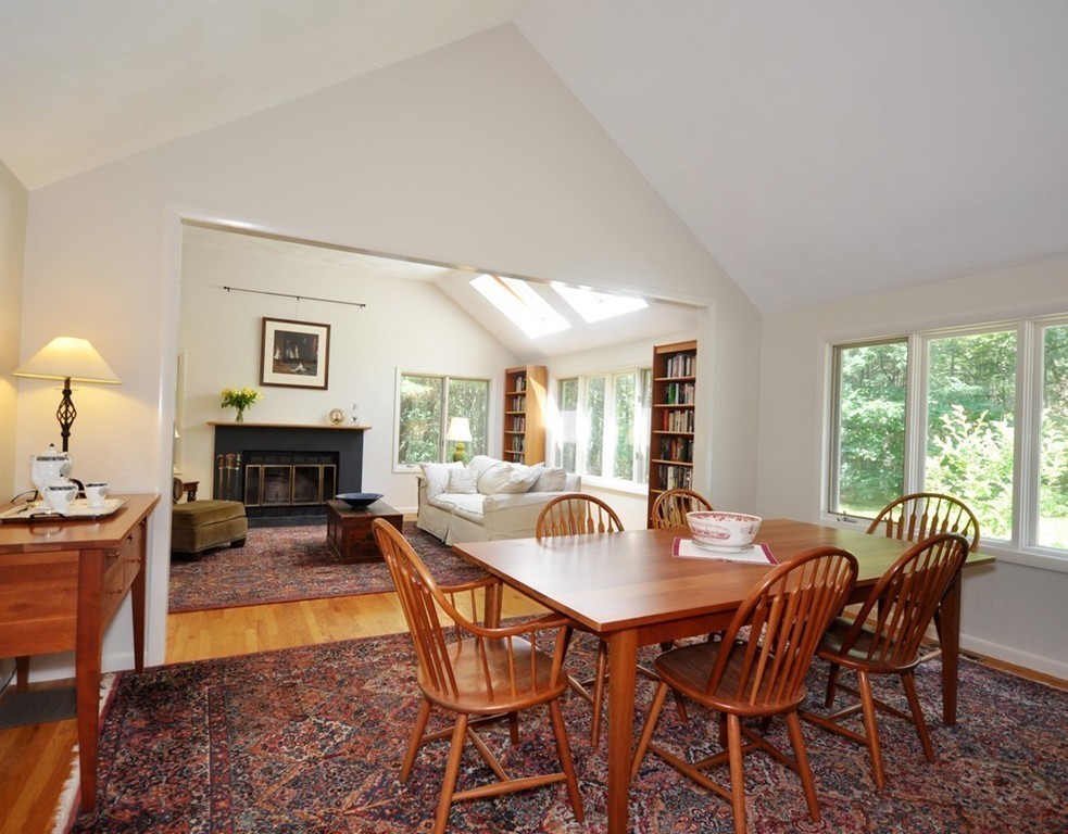 163 Sunset Road Carlisle, MA 01741 - Photo 5 of 19 a dining room with furniture a fireplace and wooden floor