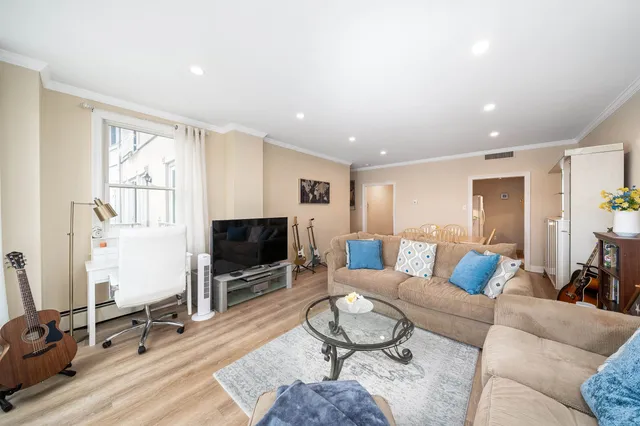 a living room with furniture a flat screen tv and a window
