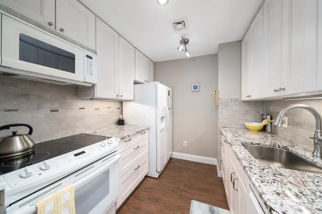 a kitchen with stainless steel appliances a stove a sink a refrigerator and cabinets