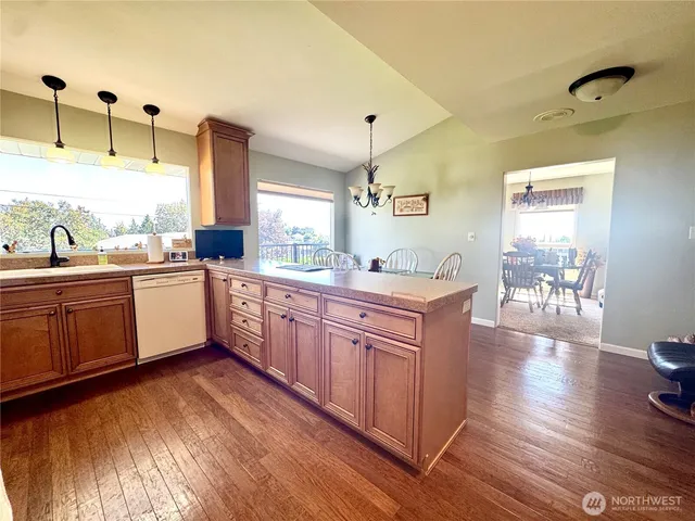 a kitchen with stainless steel appliances a sink cabinets and wooden floor