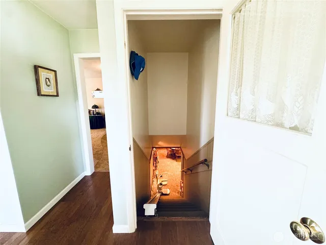 a view of a hallway with wooden floor and entryway