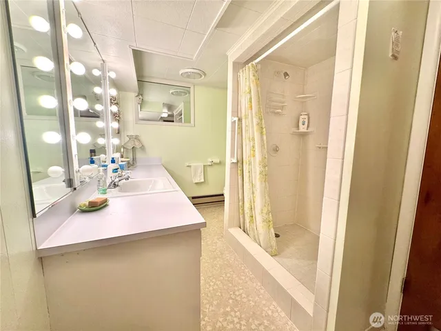 a bathroom with a sink a mirror and a shower