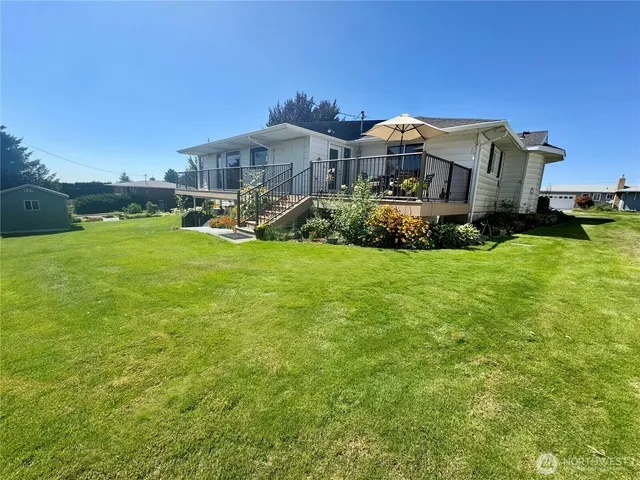 a view of a house with a big yard and large trees