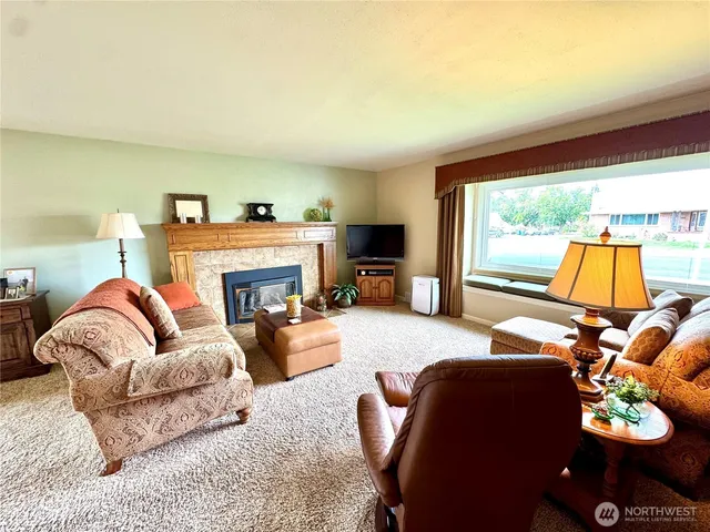 a living room with furniture fireplace and a large window