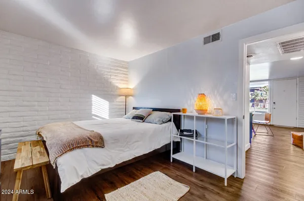 a bedroom with a bed and wooden floor
