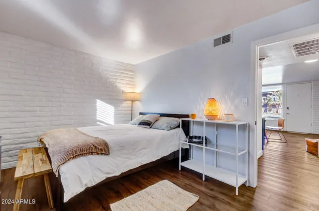 a bedroom with a bed and wooden floor