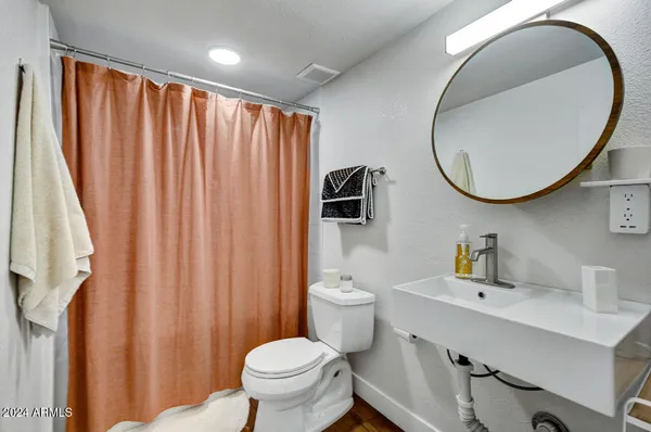 a bathroom with a sink a toilet and a mirror