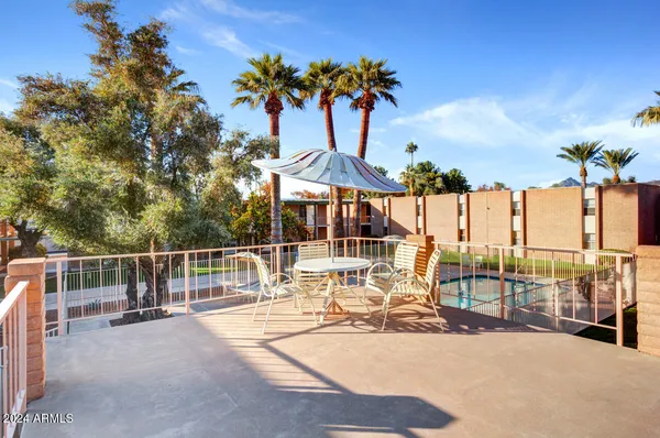 a view of a swimming pool with a patio and a yard